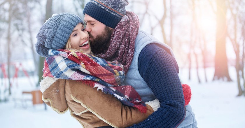 Mann küsst Frau im Schnee