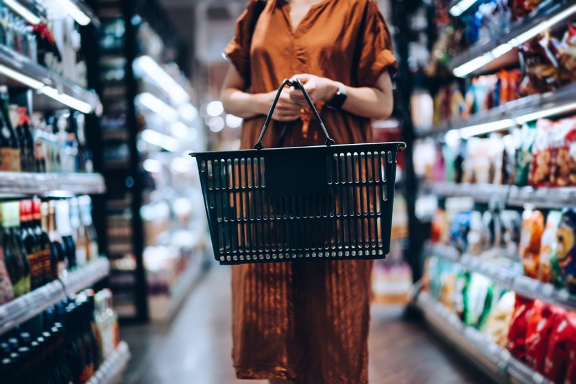Frau im Supermarkt mit Einkaufskorb